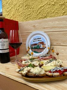 a plate of food on a table with a glass of wine at HOTEL EL MOLINO DE PANCORBO in Pancorbo