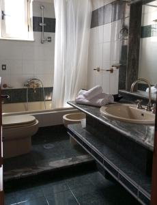 ein Badezimmer mit einer Badewanne, einem WC und einem Waschbecken in der Unterkunft Scario house in Scario