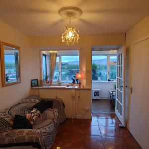 a living room with a couch and a chandelier at St Martins Old Schoolhouse Ballyroe Tralee in Tralee