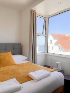 a bedroom with a bed and a large window at Reef Lodge in Newquay