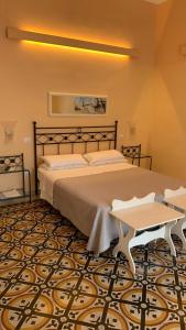 a bedroom with a large bed and a table at villa verde sul mare in Vietri sul Mare