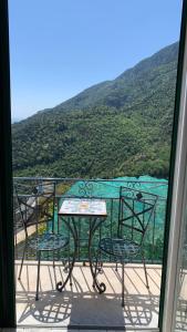 a table and chairs on a balcony with a mountain at villa verde sul mare in Vietri sul Mare