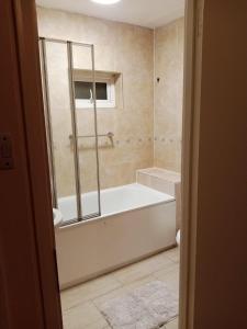 La salle de bains est pourvue d'une baignoire et d'une douche. dans l'établissement Greenwich Abode, à Londres