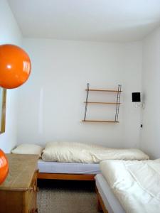 Habitación con 2 camas y un globo naranja en Chesa Crasta 6, en Samedan