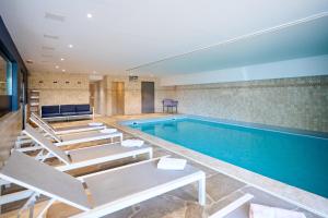 uma piscina com espreguiçadeiras num quarto de hotel em Hotel La Malle Poste em Rochefort