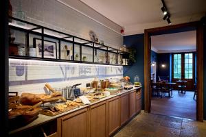 a kitchen with a counter with food on it at Hotel La Malle Poste in Rochefort