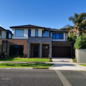 a house with a garage and a palm tree at Altona entire 3 bedrooms house in Altona