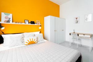- une chambre avec un lit blanc et un mur jaune dans l'établissement Luminoso appartamento vicino alle Cinque Terre (CITRA: 011015-LT-3028), à La Spezia