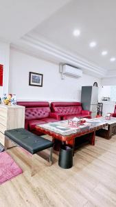Economy Class Hostel في دايوان: غرفة معيشة مع أريكة حمراء وطاولة
