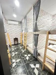 Economy Class Hostel في دايوان: غرفة مع سرير بطابقين وأرضية من البلاط