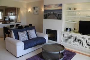 un soggiorno con un divano e un tavolo di Luxury 2 Bedroom Apartment with Private Garden a Almancil