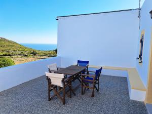a table and chairs on a balcony with a view of the ocean at Sophie's Pourko House in Kythira