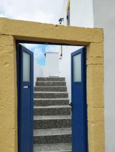 a blue door leading to a set of stairs at Sophie's Pourko House in Kythira