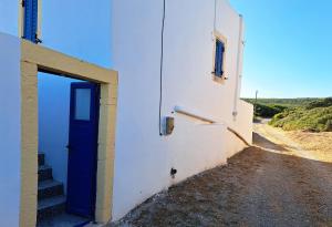 a blue door on a white building with stairs at Sophie's Pourko House in Kythira