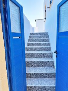 a blue door leading up a stairway with stairs at Sophie's Pourko House in Kythira