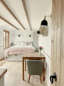 a bedroom with a bed and a table with a chair at Hidden Gem Luxury Shepherd Hut - Pea Pod in Wimbish