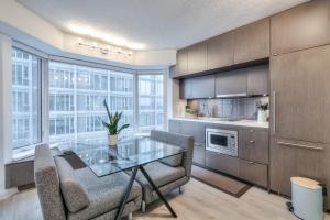 a kitchen with a glass table and chairs andwindows at Premier INN in Toronto