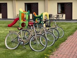 a group of bikes parked in the grass next to a building at Ośrodek "Pod Wydmami" in Sarbinowo