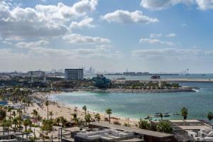 a view of a beach with palm trees and the ocean at Hyatt Centric Jumeirah Dubai - King Room - UAE in Dubai