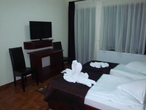 una camera d'albergo con un letto con sopra degli animali da compagnia di Club Vila Bran a Bran