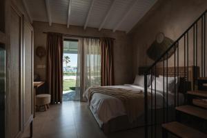 um quarto com uma cama e uma porta de vidro deslizante em Bungalows Iphigenia em Pefkohori
