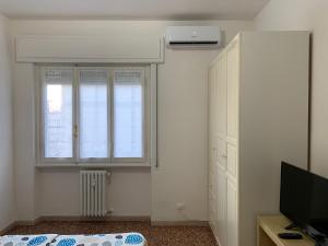 Zimmer mit einem Fenster, einem TV und einem Bett in der Unterkunft Venere Apartment in Florenz