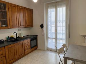 eine Küche mit Holzschränken, einem Tisch und einem Fenster in der Unterkunft Venere Apartment in Florenz