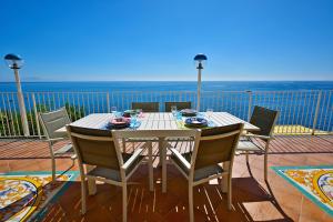 una mesa y sillas en un balcón con vistas al océano en Ravello Art Hotel Marmorata, en Ravello