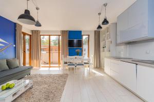 a kitchen with white cabinets and a dining room at Apartamenty NCNK Baltic Park PREMIUM w Stegnie - 500 m do plaży in Stegna