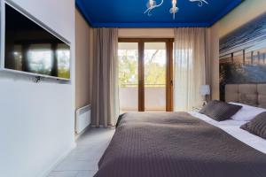 a bedroom with a large bed with a blue ceiling at Apartamenty NCNK Baltic Park PREMIUM w Stegnie - 500 m do plaży in Stegna