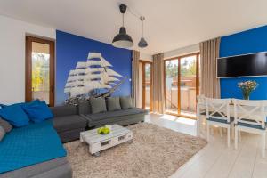 a living room with a couch and a pirate ship on the wall at Apartamenty NCNK Baltic Park PREMIUM w Stegnie - 500 m do plaży in Stegna
