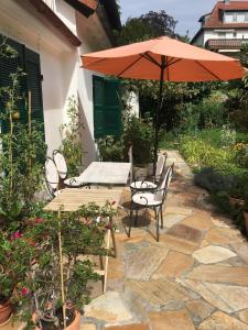 a table and chairs with an umbrella on a patio at Haus Diana in Badenweiler