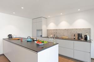 a kitchen with white cabinets and a bowl of fruit on a counter at Appartamento Lago e Monti - Happy Rentals in Locarno