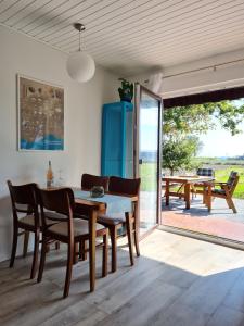 a dining room with a table and chairs and a patio at Ferienhaus Weitblick in Busenwurth