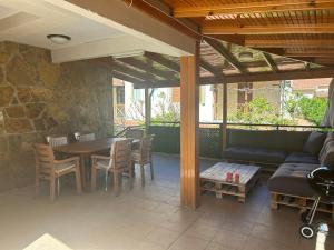 een patio met een bank en een tafel en stoelen bij Denize 200 metre, 3+1 Bahçeli Villa in Ortaköy