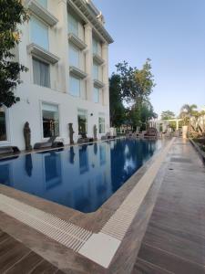 a swimming pool in front of a building at Taj Gandhinagar Resort and Spa in Gandhinagar