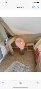um quarto com uma cama e uma mesa com um candeeiro em L‘Embellie em Moussey