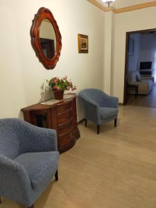 un soggiorno con sedia e specchio di Appartamento Uso Turistico Alassio ad Alassio