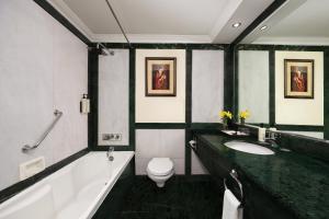 ein Badezimmer mit Badewanne, Toilette und Waschbecken in der Unterkunft V Sarovar Portico MI Road Jaipur in Jaipur + 21 Fotos