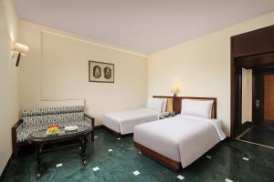 Ein Bett oder Betten in einem Zimmer der Unterkunft V Sarovar Portico MI Road Jaipur