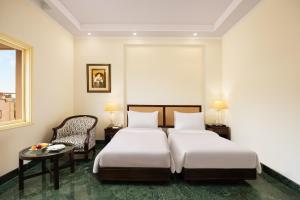 Ein Bett oder Betten in einem Zimmer der Unterkunft V Sarovar Portico MI Road Jaipur