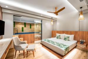 a bedroom with a bed and a tv and a chair at HOLITEL ANJUNA GOA in Anjuna