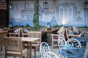 ベリー・セント・エドマンズにあるDog and Partridge by Greene King Innsのテーブルと椅子、壁画のあるレストラン