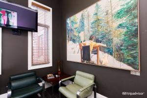 Tolarno Hotel - Mirka’s Studio - Australia في ملبورن: غرفة انتظار مع كرسيين و لوحة كبيرة على الحائط