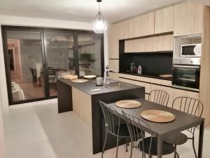 a kitchen with a table and some chairs in it at ALOJAMIENTO EN CULLERa in Cullera +6 photos