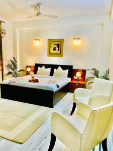 um quarto com uma cama e 2 cadeiras em BedChambers Service Apartment, South City 1 em Gurgaon