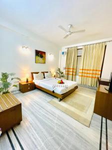 sypialnia z łóżkiem i wentylatorem sufitowym w obiekcie BedChambers Service Apartment, South City 1 w mieście Gurgaon