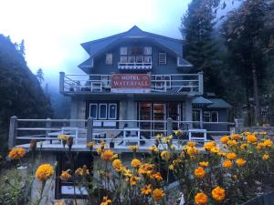 a building with a bunch of flowers in front of it at Hotel waterfall,Benkar in Phakding