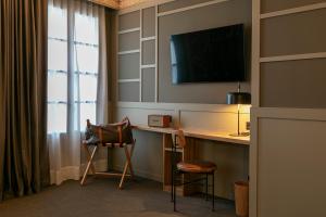a hotel room with a desk and a television at Hotel La Pau in Barcelona