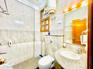uma casa de banho com um WC branco e um lavatório. em BedChambers Service Apartment, South City 1 em Gurgaon